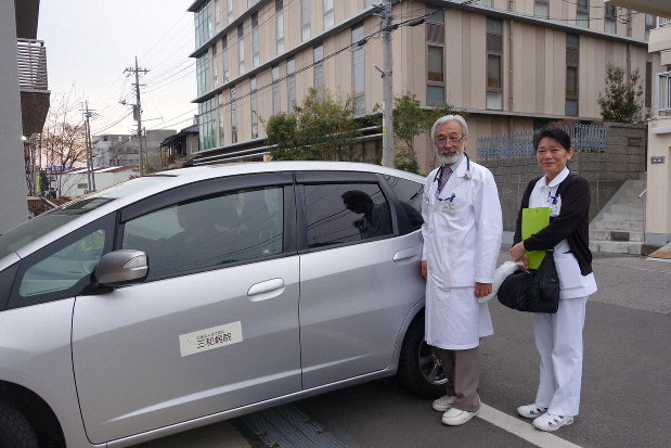 看護師と一緒に、受け持つ患者の家を車で訪問する