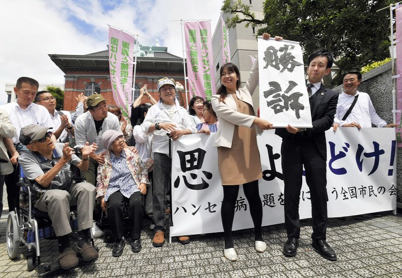 支援者の前で「勝訴」の紙を掲げる原告の弁護士=熊本市の熊本地裁前で2019年6月28日午後2時2分、田鍋公也撮影