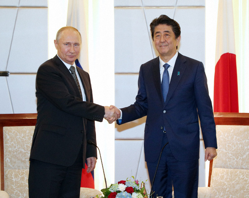首脳会談を前に握手するロシアのプーチン大統領(左)と安倍晋三首相=大阪市中央区で2019年6月29日午後5時57分(代表撮影)