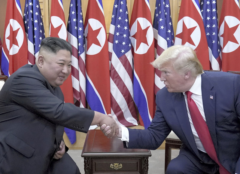 板門店で会談し握手するトランプ米大統領(右)と北朝鮮の金正恩朝鮮労働党委員長=30日、ロイター