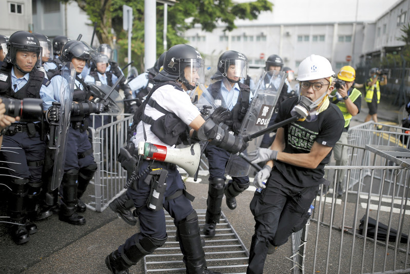 香港返還22周年記念式典の会場近くで、デモ隊を排除しようとする警官隊=香港で1日、ロイター