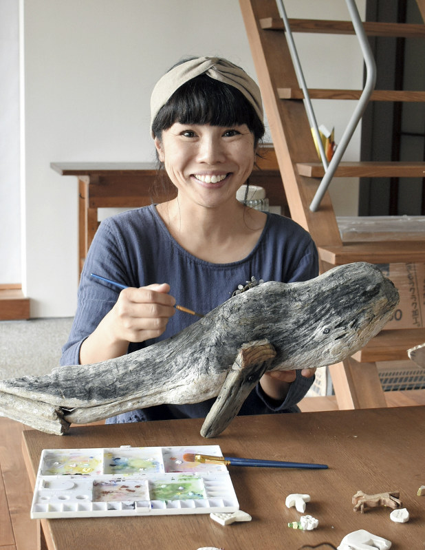 海岸で清掃活動し、流木に色づけをする嶋津裕子さん=千葉県富津市で