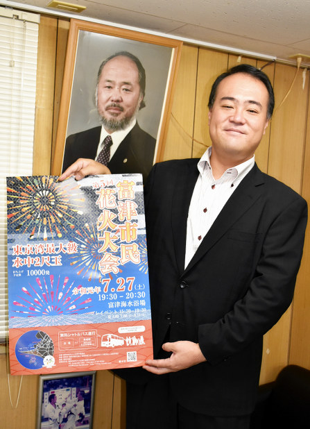 今年の市民花火大会のポスターを手にする平野寛明実行委員長=千葉県富津市で