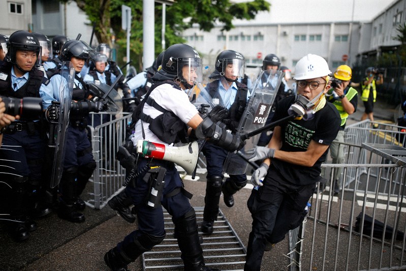 香港返還22周年記念式典の会場近くで、デモ隊を排除しようとする警官隊=香港で1日、ロイター