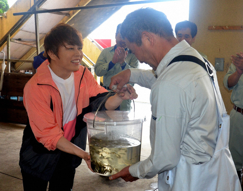ニゴロブナの稚魚を寄付する西川貴教さん(左)=滋賀県守山市木浜町の木浜漁港で2019年7月1日午前9時2分、礒野健一撮影