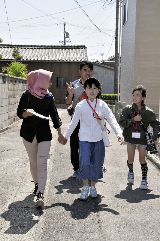バディーの子どもたちと手をつなぎ、スタンプラリーをする技能実習生たち=愛知県高浜市で、太田敦子撮影