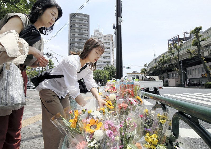 母子が亡くなった事故の現場で献花する人々=東京都豊島区で5月18日、玉城達郎撮影
