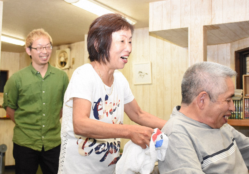 長男宙さん(左)の理髪店で働く兵頭千恵さん(中央)。なじみの客の散髪を終え、「また来てね」と笑顔を見せた=愛媛県西予市野村町地区で2019年6月14日午前11時1分、中川祐一撮影