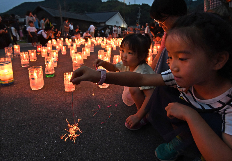 分灯された「希望の灯り」からつけられた線香花火を見つめる子供たち=愛媛県宇和島市で2019年7月7日午後7時37分、山崎一輝撮影