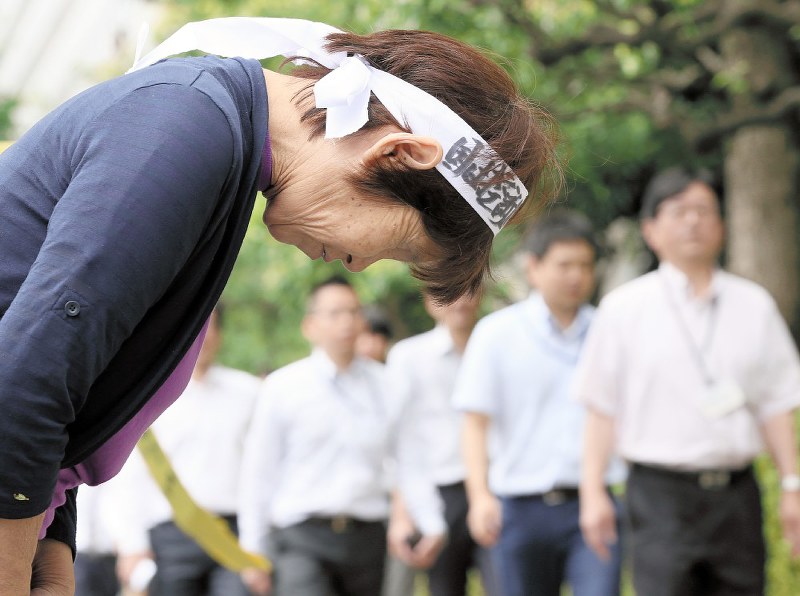 控訴断念を訴えて通行人に頭を下げる女性=東京都千代田区で2019年7月8日午後0時37分、吉田航太撮影