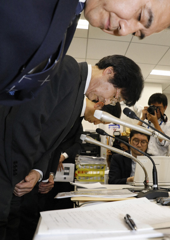 記者会見で頭を下げるセブン・ペイの小林強社長(中央)ら=東京都千代田区で2019年7月4日、尾籠章裕撮影