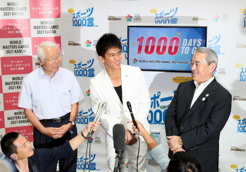 ワールドマスターズゲームズ2021関西の開催1000日前を記念し、空港ロビーに設置されたカウントダウンの残日計の前で語り合う松本正義関経連会長(右)、井戸敏三兵庫県知事(左)、タレントの武井壮さん=関西国際空港で2018年8月18日、幾島健太郎撮影