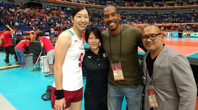 昨年10月に横浜アリーナで行われた世界選手権のコート脇で、一緒に写真を撮る荒木(左端)と猪野さん(右端)。右から2人目は、猪野さんが日本でマネジメントを担当する陸上三段跳びの米国代表選手、クリスチャン・テーラー=猪野さん提供