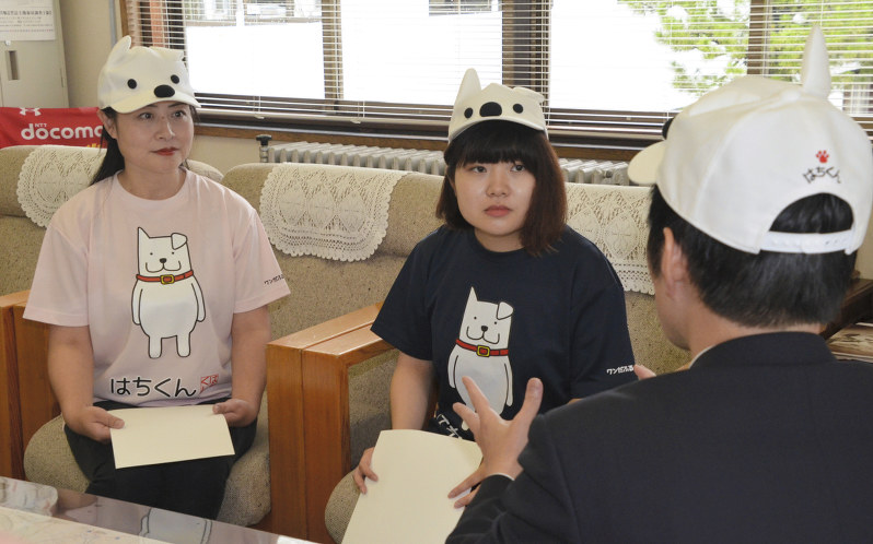 秋田犬ふれあい隊3期生として福原淳嗣市長(手前右)から激励を受ける藤川琴里さん(中央)、馬鳴さん=秋田県大館市役所で