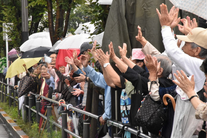 候補に手を振る人たち=東京都江東区で、2019年7月14日午後1時59分=須藤孝撮影
