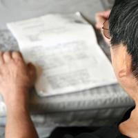 生活保護費の通知書を眺め、将来への不安を口にする女性＝青森市内で