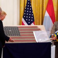 　第２次大戦中の１９４４年６月６日に、ノルマンディー上陸作戦の一環としてドイツ占領下フランスのユタ・ビーチに上陸した部隊が使用した米国旗が米国に「帰還」した。写真はトランプ米大統領（左から２人目）やオランダのルッテ首相（右）。ワシントンで撮影（２０１９年　ロイター／Kevin Lamarque）