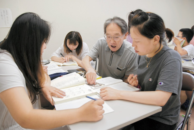 松戸自主夜間中学のスタッフから日本語を学ぶ中国籍の生徒たち=千葉県松戸市で、堀智行撮影
