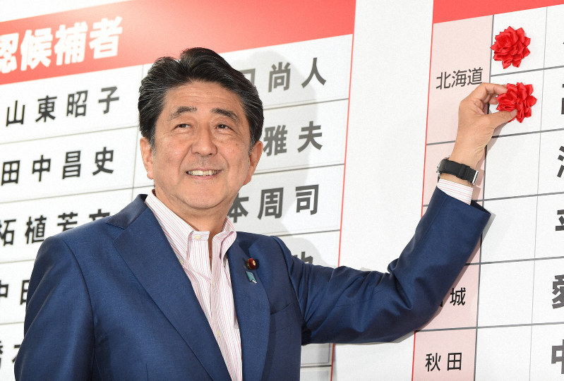 当選確実となった候補者の名前に花をつける安倍晋三首相=東京都千代田区で2019年7月21日午後9時43分、滝川大貴撮影