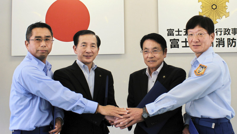 相互応援協定に調印した富士五湖消防本部と都留市消防本部の関係者=山梨県富士吉田市で