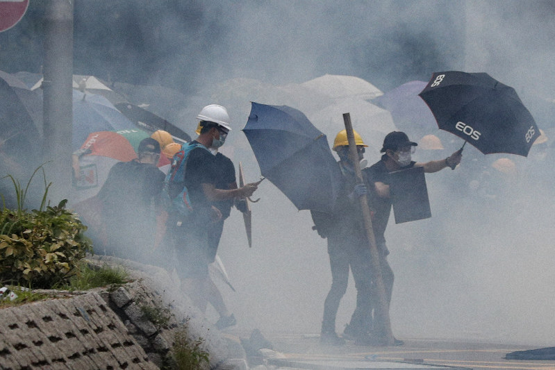抗議デモの参加者に向けて警官隊が発射した催涙弾の煙=香港の元朗地区で2019年7月27日、AP