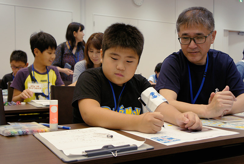 新聞製作体験イベントで記事をまとめる小学生ら=大阪府門真市のパナソニックミュージアムで、堀文彦撮影