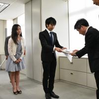 東京都教委の担当者（右）に署名を提出する駒崎弘樹さんや黒染め指導を受けた経験のある女性ら＝東京都新宿区の都庁で2019年7月30日午前11時39分、大久保昂撮影