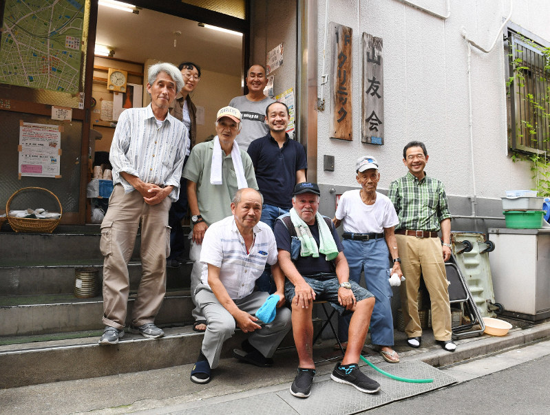 山友会クリニックの前に集まったルボ・ジャンさん(前列左から2人目)と山谷地区の元労働者ら=東京都台東区で2019年7月26日、根岸基弘撮影