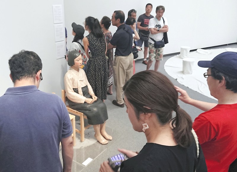 「表現の不自由展・その後」コーナーで、大勢の来場者が鑑賞する「平和の少女像」=名古屋市東区の愛知芸術文化センターで2019年8月3日午後1時26分、山田泰生撮影