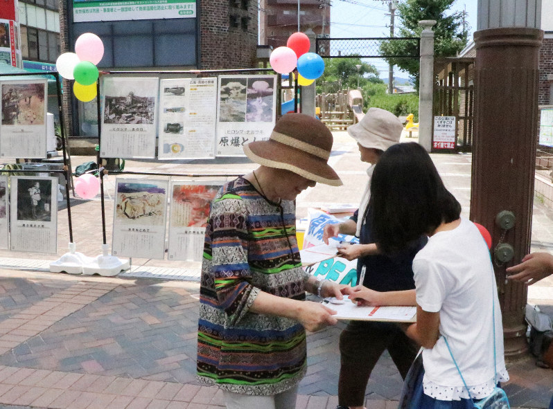 「原爆写真展」に合わせて実施された署名活動で署名する人たち=長崎県佐世保市で2019年8月4日午後0時6分、綿貫洋撮影