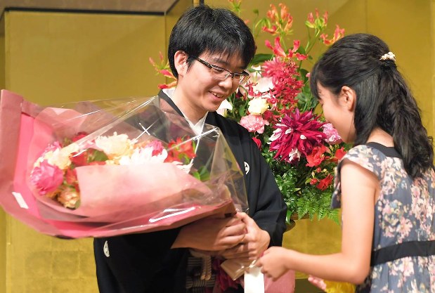 名人就位式で花束を受け取り、笑顔を見せる豊島将之名人(左) 滝川大貴撮影