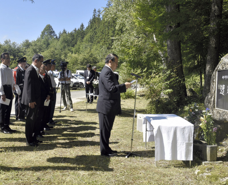 慰霊碑の前で追悼の言葉を述べる牧野光朗市長=長野県飯田市上飯田松川入で