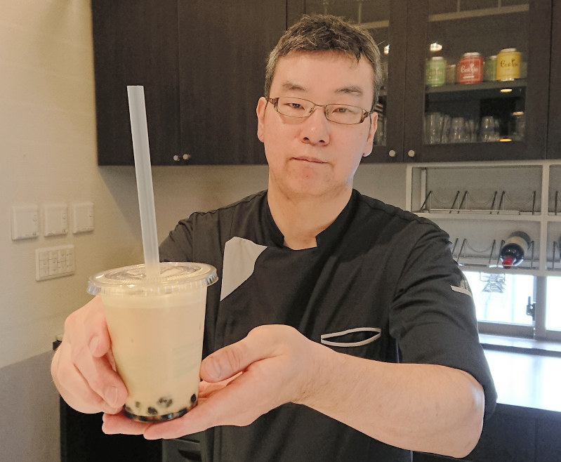 「あんこミルクティーの飲む水まんじゅう」を手にする白木亮年さん=岐阜県大垣市内原で