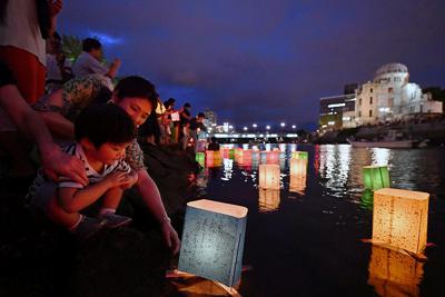 平和への祈りを込めて元安川に灯籠を流す人たち＝広島市中区で２０１９年８月６日午後７時３８分、猪飼健史撮影