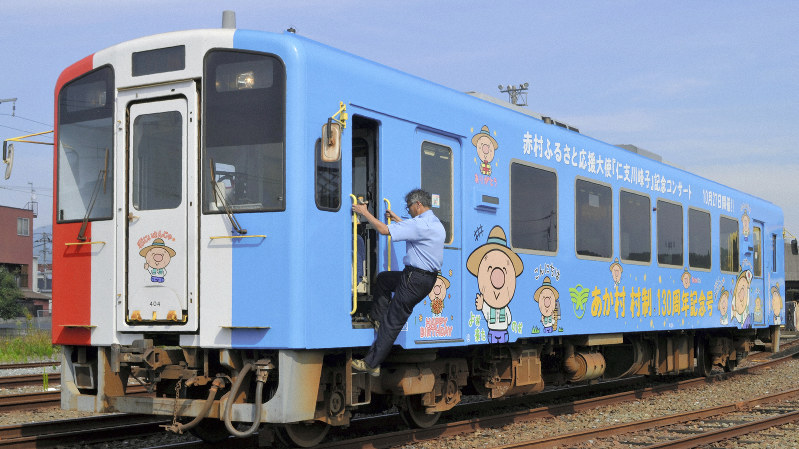福岡県赤村130周年記念ラッピング列車。正面や側面に描かれたキャラクターが源じいさん=福岡県福智町で、峰下喜之撮影