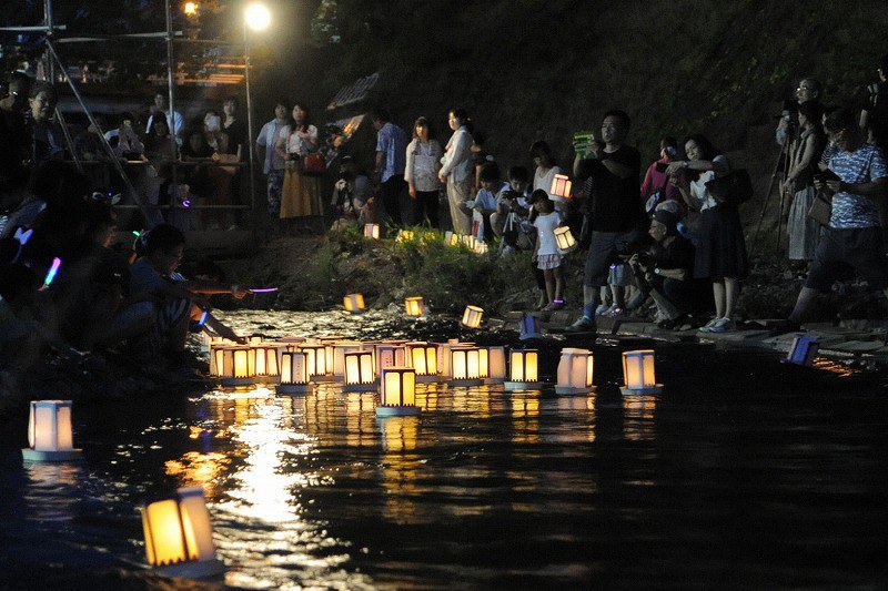 それぞれの願いを込め灯籠を流す市民たち=滋賀県彦根市芹橋で、西村浩一撮影