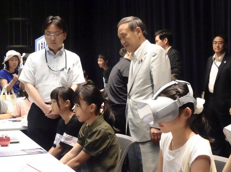 VRで拉致問題を学ぶ子どもたちを見守る菅義偉官房長官(中央)=東京都千代田区の中央合同庁舎8号館で2019年8月8日、高橋克哉撮影