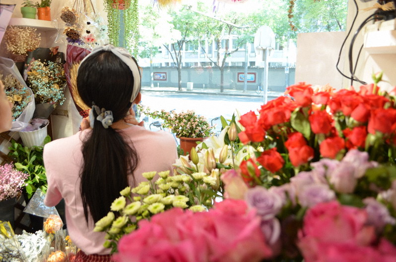 花を選ぶ女性。離婚後もDVと向き合う日々が続く=北京市海淀区で、浦松丈二撮影