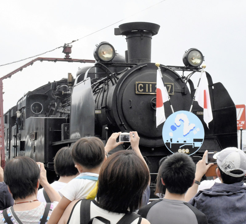 2周年記念のヘッドマークを着けたSL大樹を撮影する観光客ら=栃木県日光市鬼怒川温泉大原の鬼怒川温泉駅で