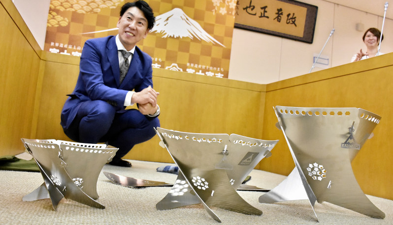 3種類のたき火台を並べて説明する小林工業の土屋鋭二さん=静岡県富士宮市で