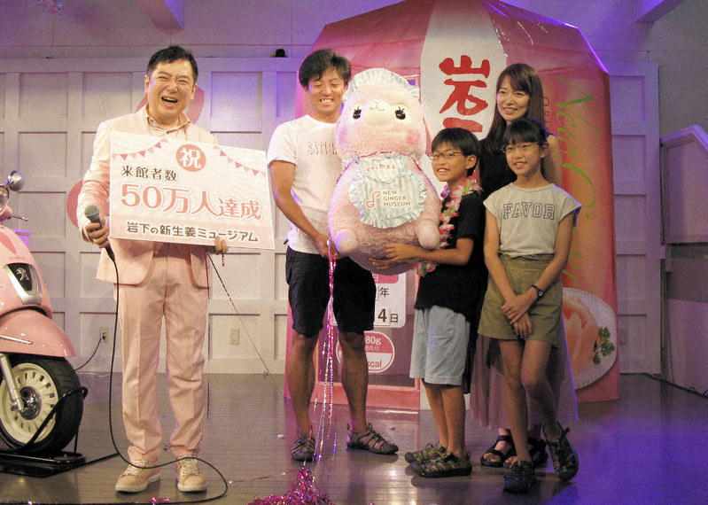 岩下和了社長(左)から記念品を受け取る宮崎誠太朗さん(右から3人目)と家族=岩下の新生姜ミュージアム提供