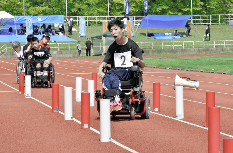 車椅子で障害物の間をすり抜ける「スラローム」に臨む選手=青森市の県総合運動公園陸上競技場で