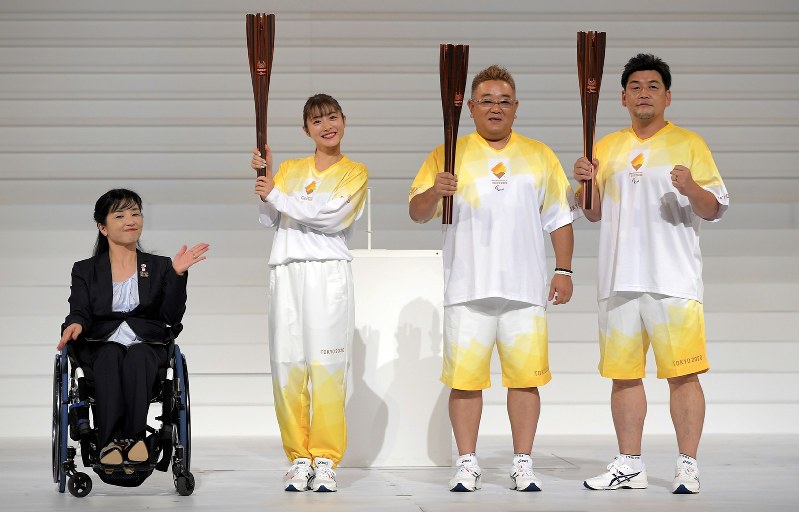 セレモニーで、聖火リレーのユニホームを紹介する、(左から)公式アンバサダーの田口亜希さん、石原さとみさん、サンドウィッチマンの伊達みきおさん、富沢たけしさん=東京都渋谷区のNHKホールで2019年8月25日、手塚耕一郎撮影