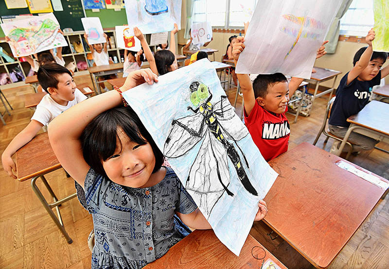 夏休みの宿題の絵を見せ合う大阪市立大隅西小学校の児童たち=大阪市東淀川区で2019年8月26日午前9時32分、山崎一輝撮影