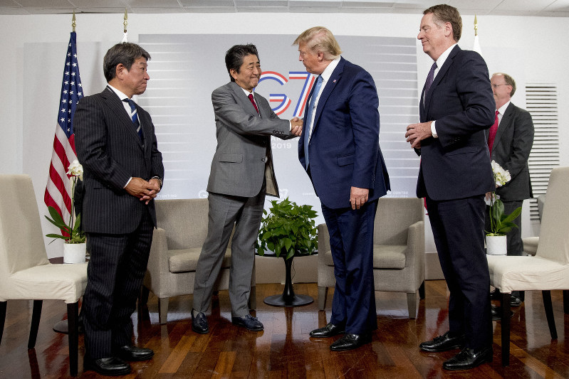 共同記者発表で握手する安倍首相とトランプ米大統領。左は茂木経済再生担当相。トランプ氏の右隣はライトハイザー米通商代表=フランス南西部のビアリッツで25日、AP