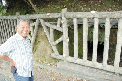 旧西原村役場壕の入り口前で語る當眞嗣一さん＝沖縄県西原町で