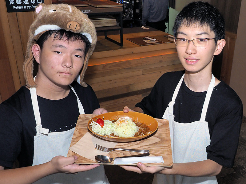 田倉主税さん(右)ら工学院大付属中高の生徒たちが考案した大山ジビエのキーマカレー=鳥取県大山町で、横井信洋撮影