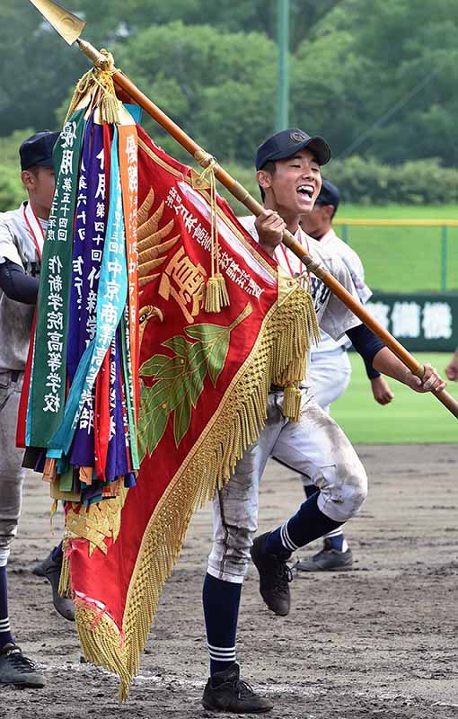 優勝旗を持ち、閉会式で場内一周する中京学院大中京の村瀬仁紀主将=兵庫県明石市の明石トーカロ球場で2019年8月31日、平川義之撮影