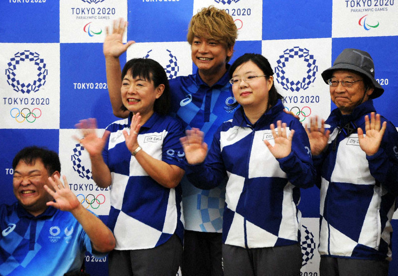 東京五輪・パラリンピックのボランティアユニホームに身を包み、発表記者会見で笑顔を見せる香取慎吾さん(中央)ら=東京都中央区で2019年7月19日、鈴木健太撮影