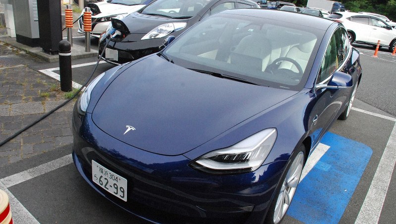 東名高速のサービスエリアで新旧の日産リーフと並ぶテスラモデル3=静岡県御殿場市で8月6日、川口雅浩撮影